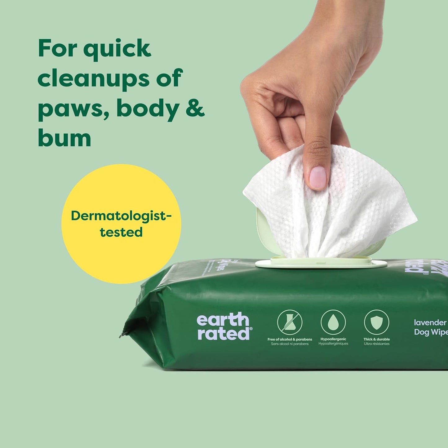 Earth Rated dog wipes with a hand taking a wipe, on a green background